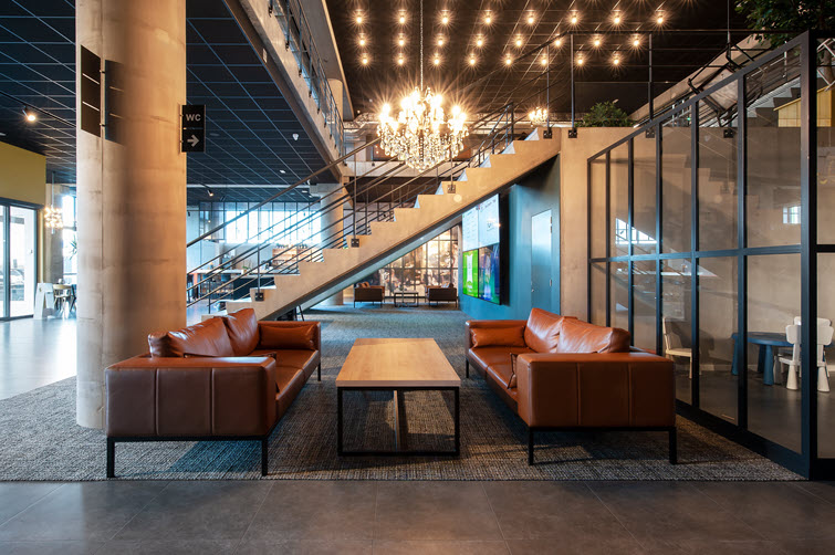 In the eclectic foyer, guests can relax around tables with HPL tops